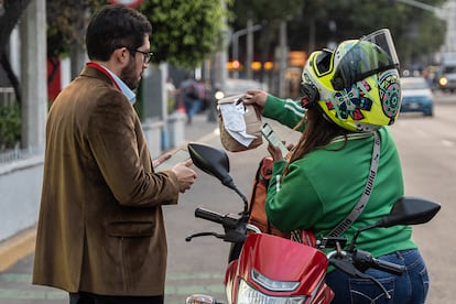 Beatriz Adriana Luciano entrega un pedido a un cliente.