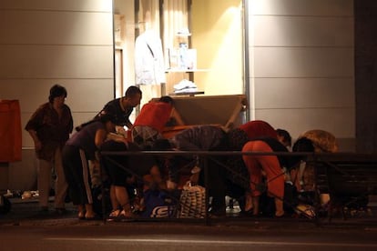 Un grupo de personas busca comida en el contenedor de basura de un centro comercial madrileño en junio de 2012.