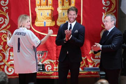 La presidenta de la Comunidad de Madrid Cristina Cifuentes posa con la camiseta del Real Madrid serigrafiada con su nombre y el número uno junto al jugador Sergio Ramos y al presidente del club Florentino Pérez.