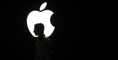 Un hombre, frente al logo de Apple.