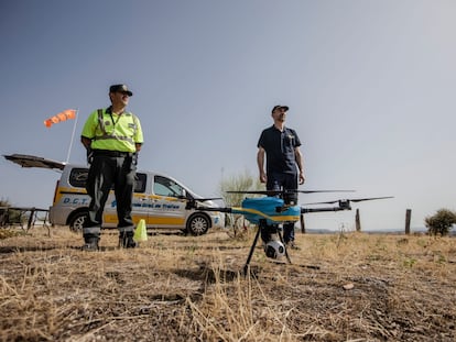 El guardia civil Javier (izq) y Javier Ibañez, operador de drones de la Dirección General de Tránsito posan junto a uno de los drones utilizados para supervisar la circulación. 13 de agosto, 2021. Villa del Prado. Comunidad de Madrid. Foto: Saúl Ruiz.