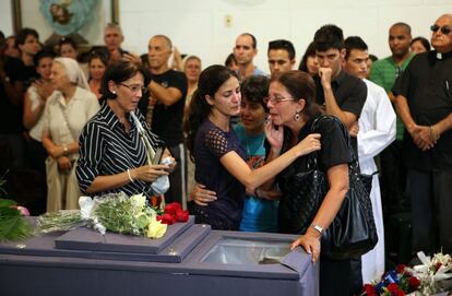 La viuda de Payá, Ofelia Acevedo (a la derecha), y su hija Rosa María, junto al féretro.