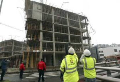 Efectivos del cuerpo de bomberos junto al edificio de viviendas en construcción en San Sebastián donde hoy se ha desplomado un andamio causando la muerte a un trabajador y otros dos se encuentran heridos.