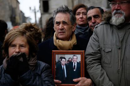 Un hombre sujeta una fotografía de Adolfo Suárez, en el exterior de la Catedral de Ávila, donde será enterrado el primer presidente de la democracia.