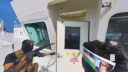 Houthi fighters open the door of the cockpit on the ship's deck in the Red Sea in this photo released November 20, 2023