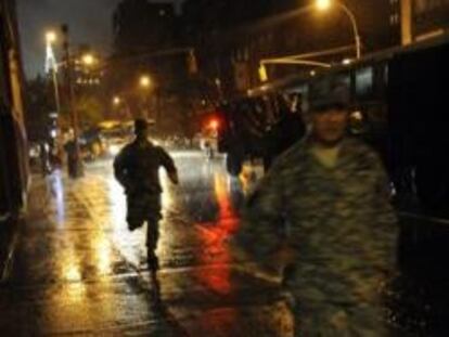 Oficiales de la Guardia nacional corren hacia el Regimiento 69 en donde permanecen durante el paso del huracán Irene en Nueva York (EE.UU.)