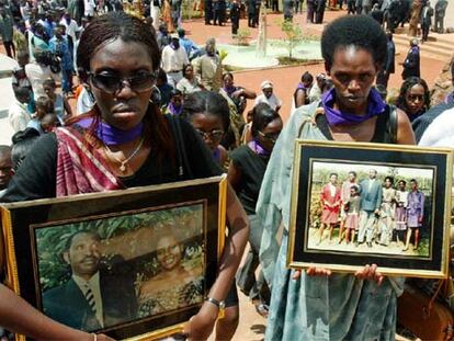 Dos supervivientes ruandesas muestran fotografías de familiares víctimas del genocidio en abril de 2004.