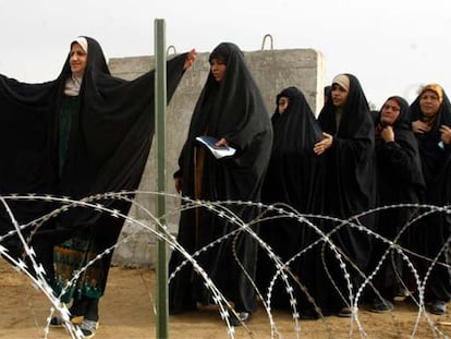 Una mujer iraquí levanta los brazos para ser cacheada antes de votar en la provincia de Al Anbar.