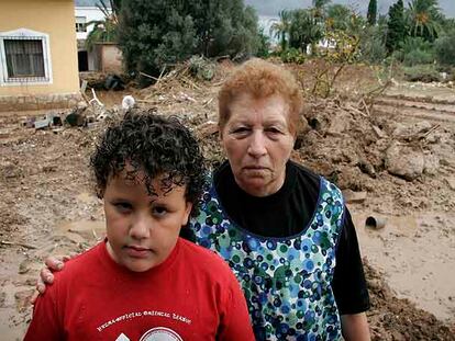 Rosario y uno de sus nietos, en el patio de su casa en El Verger.