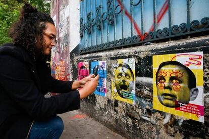 Eleitora tira foto de um mural com críticas a candidatos em São Paulo.