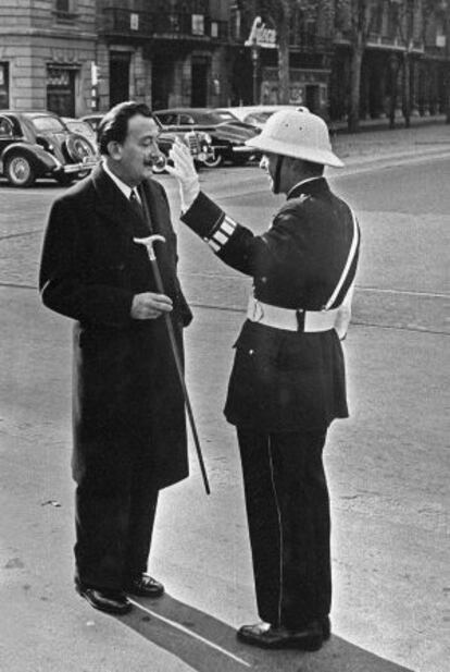 Dalí, el 1958, junto a un guardia urbano en una calle de Barcelona.