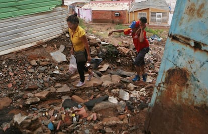 Dos venezolanos entre escombros en Maracaibo.  