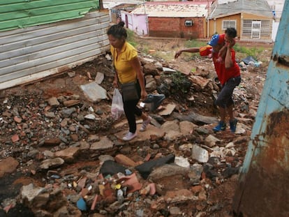 Dois venezuelanos entre entulho em Maracaibo.