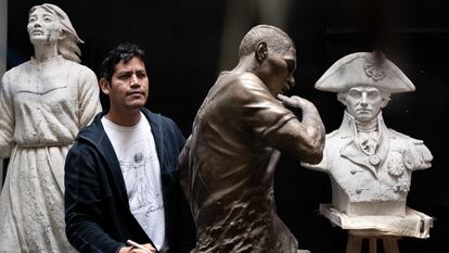 Jose Carlos Vargas junto a la escultura del futbolista Paolo Guerrero, en su taller de Lima, el 20 de septiembre.