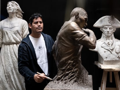 Jose Carlos Vargas junto a la escultura del futbolista Paolo Guerrero, en su taller de Lima, el 20 de septiembre.
