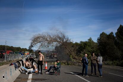 Varios agricultores descansan, mientras los tractores siguen bloqueando este miércoles la autopista AP-7 en Pontós (Girona).