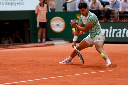 El español Carlos Alcaraz anota de espaldas al serbio durante el tercer juego del segundo 'set'. 