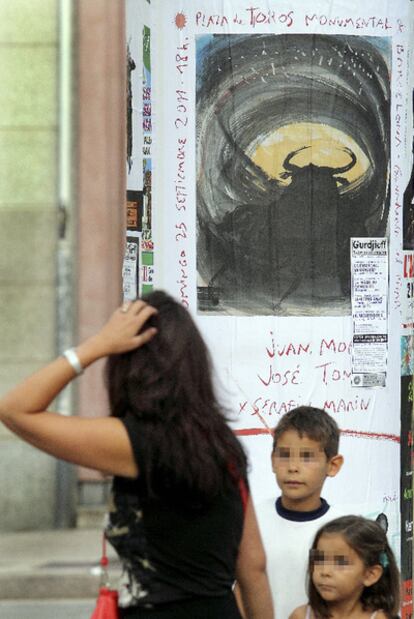 Una mujer contempla el cartel de Barceló que anuncia la última corrida de toros en Barcelona.