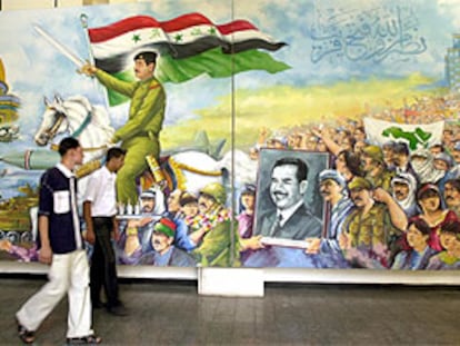 Dos jóvenes iraquíes pasan junto a un mural que representa a Sadam Husein dirigiéndose a conquistar Jerusalén.