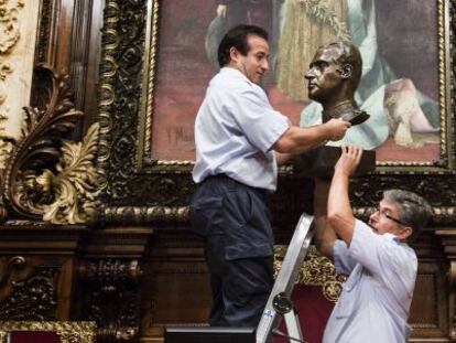 Dos funcionarios retiran el busto de Juan Carlos I del Ayuntamiento de Barcelona el 23 de julio de 2015.