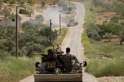 Rebel fighters of the Al-Furqan brigade follow a tank on a pick-up truck as they drive along a road during what they said is an offensive to take control of the al-Mastouma army base which is controlled by forces loyal to Syria's President Bashar al-Assad near Idlib city May 17, 2015. Picture taken May 17, 2015. REUTERS/Khalil Ashawi