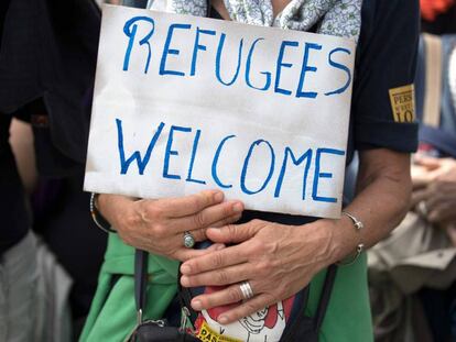 Un manifestante sostiene una pancarta que dice 'Refugiados bienvenidos' durante una concentración en París.
