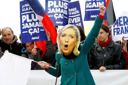 Una mujer con una m&aacute;scara de Marine Le Pen en un mitin en Par&iacute;s.