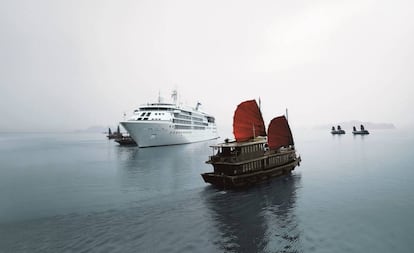 Un crucero junto a barcos tradicionales en la bahía de Halong (Vietnam).