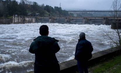 Dos personas observan la crecida del río Miño en el embalse de Velle (Ourense).