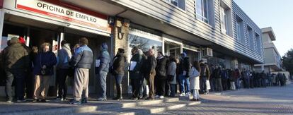 People standing in line outside a Madrid employment office.