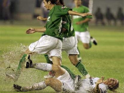 Guti cae arrollado por dos jugadores chinos durante la gira asiática del Madrid.