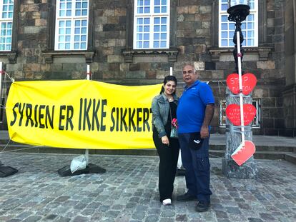 Mohamed Alderi y su hija Sara, refugiados sirios en Dinamarca, el jueves frente al Parlamento. En el cartel se lee en danés “Siria no es segura”. / C. G.