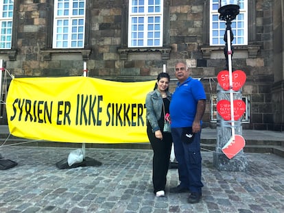 Mohamed Alderi y su hija Sara, refugiados sirios en Dinamarca, el jueves frente al Parlamento. En el cartel se lee en danés “Siria no es segura”. / C. G.