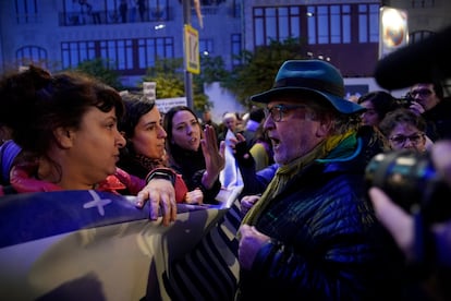 Un hombre discute con un grupo de mujeres que sujetan la pancarta de "Irene Montero Dimisión" durante la manifestación por la Gran Vía de Madrid.