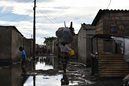 Vecinos de un barrio de Lusaka (Zambia) afectado por un brote de cólera caminan por una calle inundada este 18 de enero.