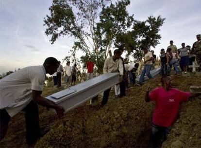 Dos hombres cargan el ataúd de un fallecido a causa del huracán Gustav, durante el entierro de varias víctimas en Santo Domingo.