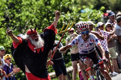 Julian Alaphilippe coge el tridente de un aficionado disfrazado de demonio, en la decimoséptima etapa del Tour. 