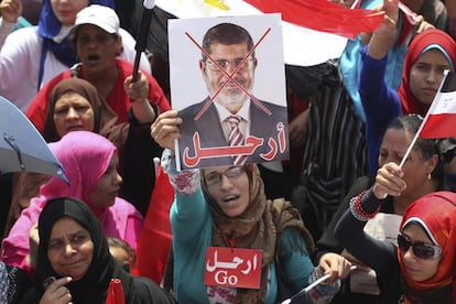 Una opositora del presidente egipcio Mohamed Mursi muestra una pancarta con el rostro de Mursi tachado, durante una manifestación en la plaza Tahrir, en El Cairo (Egipto), 2 de julio de 2013. Los Hermanos Musulmanes y los aliados islamistas del presidente han llamado a sus seguidores a salir en masa a las calles del país, mientras que los opositores aspiran a volver a sacar a millones de personas contra Mursi, como ya hicieron el pasado domingo. 