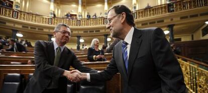El presidente del Gobierno, Mariano Rajoy, estrecha la mano del ministro de Justicia, Alberto Ruiz Gallard&oacute;n, en el Congreso de los Diputados. 