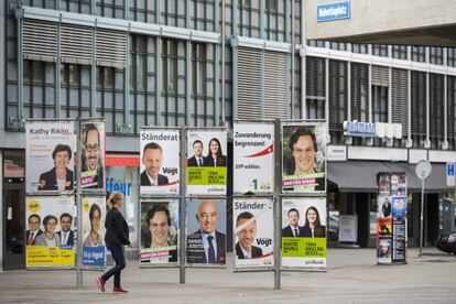 Una mujer pasa delante de carteles electorales, en Zurich, el 28 de  septiembre.