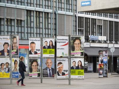 Una mujer pasa delante de carteles electorales, en Zurich, el 28 de  septiembre.