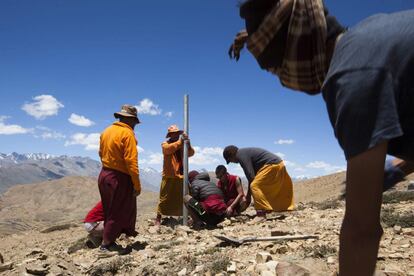 Monjes y residentes budistas indios montaron un poste de metal en una colina para establecer nuevas banderas de oración antes de un festival en el monasterio Tnagyud Gompa.