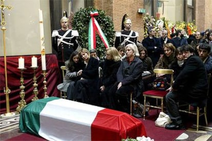 Familiares de Calipari ante su féretro, cubierto con la bandera italiana. En primera fila, su viuda (segunda por la izquierda).