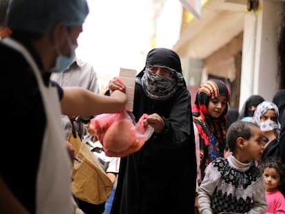 Una mujer recibe una ración de comida este julio en Saná, en Yemen.