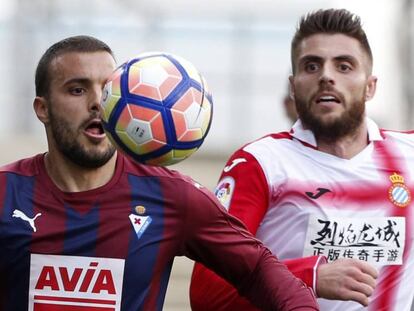 Pedro León controla el balón ante David López.