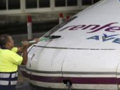 Un operario de Renfe limpia un tren de alta velocidad.