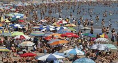 Cientos de personas disfrutan del sol en la playa de la Malvarrosa después de que ayer tuviera que prohibirse el baño durante toda la tarde por el avistamiento de tres peces raya cercanos a la costa.