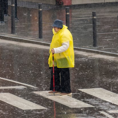 TERUEL, 03/03/2025.- Una mujer cruza un paso de cebra bajola lluvia este lunes en Teruel en el que la Agencia Estatal de Meteorología (Aemet) anuncia para Aragón cielo muy nuboso o cubierto con precipitaciones débiles generalizadas, más probables e intensas en el sureste de la Iberica. EFE/ Antonio García