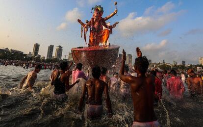 Devotos indios portan una figura del dios hindú Lord Ganesha para sumergirse en el Mar Arábigo, como parte de un ritual del festival Ganpati en Mumbai (India).