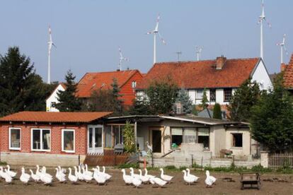 Los molinos de energ&iacute;a e&oacute;lica se ven tras los tejados de la localidad alemana Dardesheim.